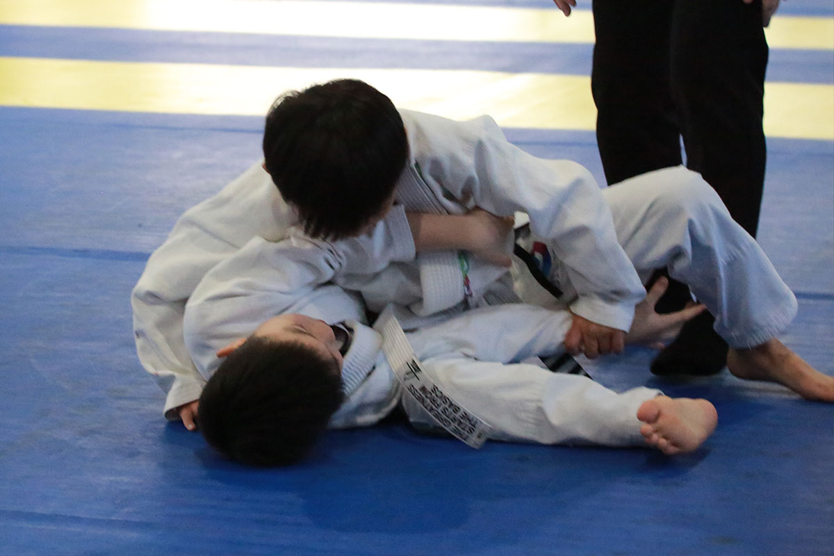 Kids aged 5-8 smiling during Brazilian Jiu-Jitsu Youth class at Catch Jiu Jitsu Kaohsiung — grappling games and safe drills